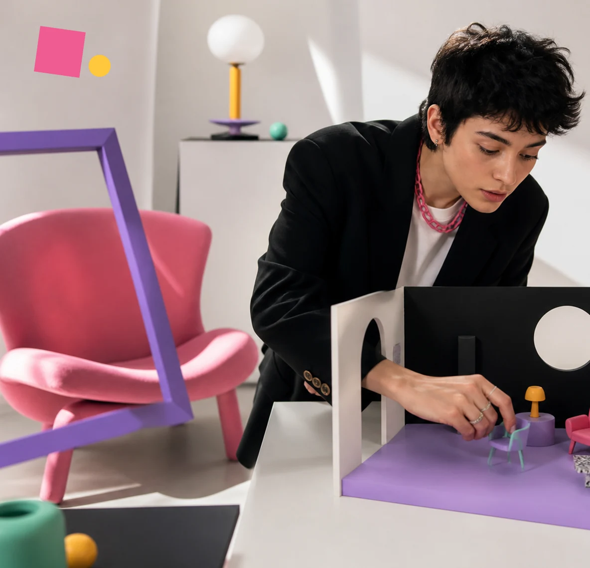 A brand concept of a creator arranging a miniature scene with colourful objects